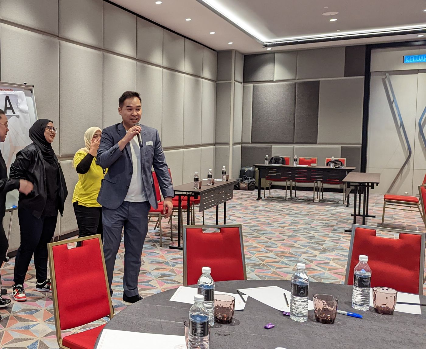 Edward Chan Waihong facilitating a group activity with a microphone