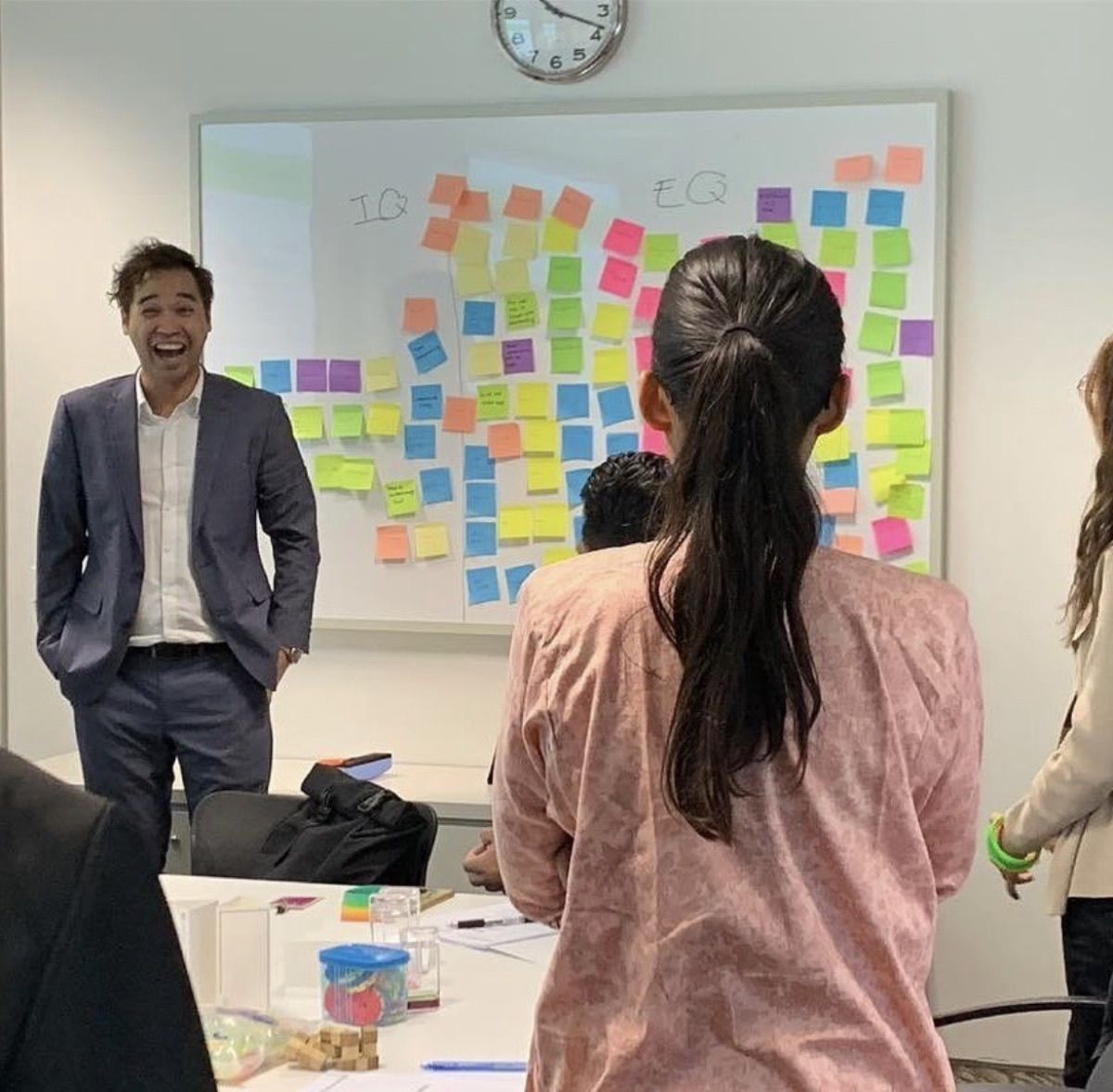 Edward Chan facilitating a team workshop on Psychological Safety in front of a wall of sticky notes
