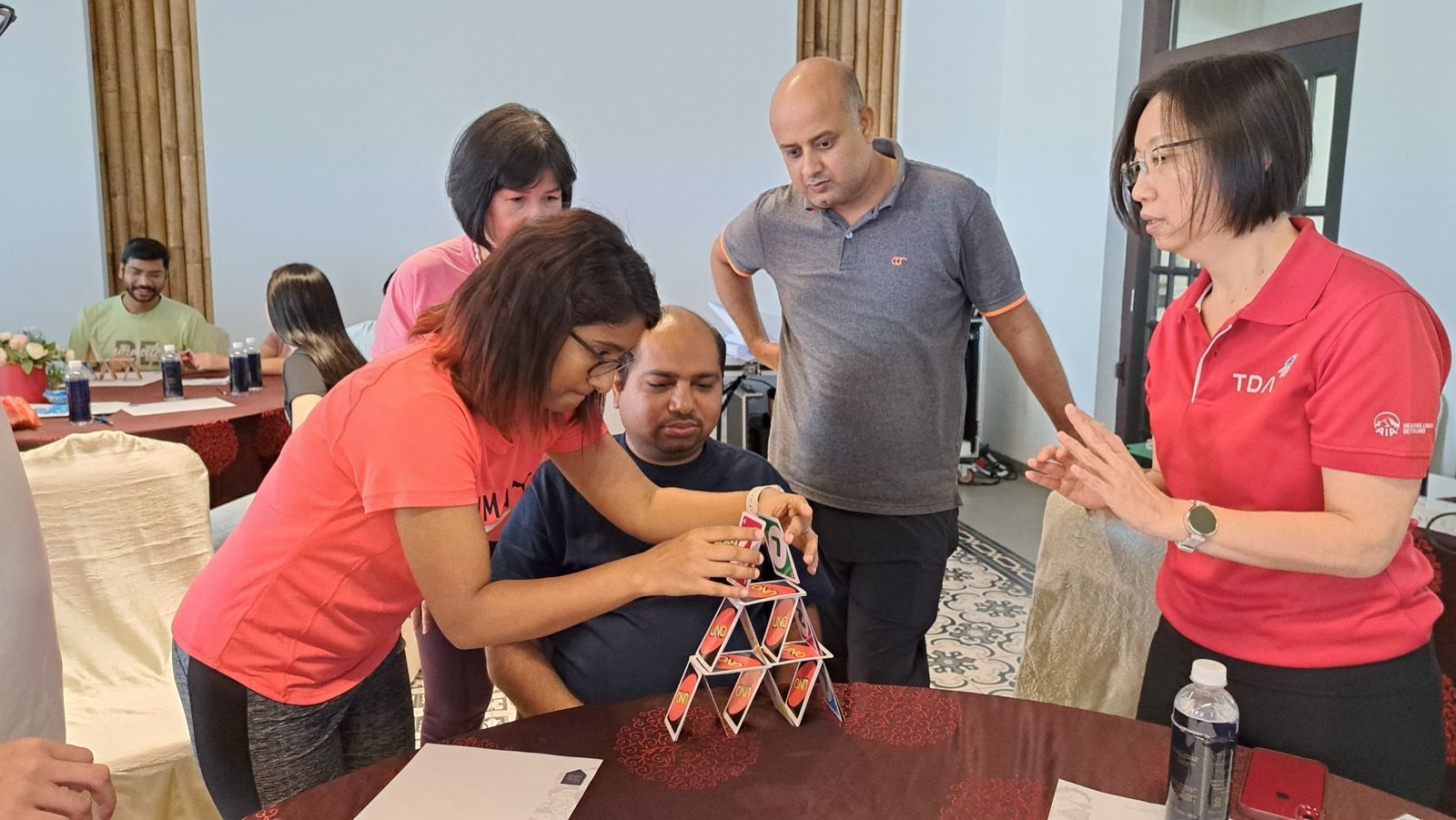 Participants building a card tower together