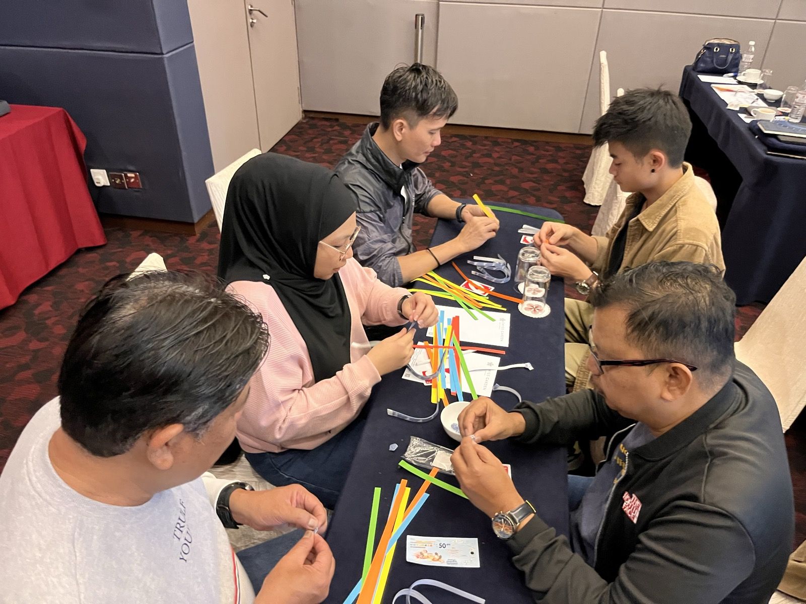 A team building a structure from straws in a simulation